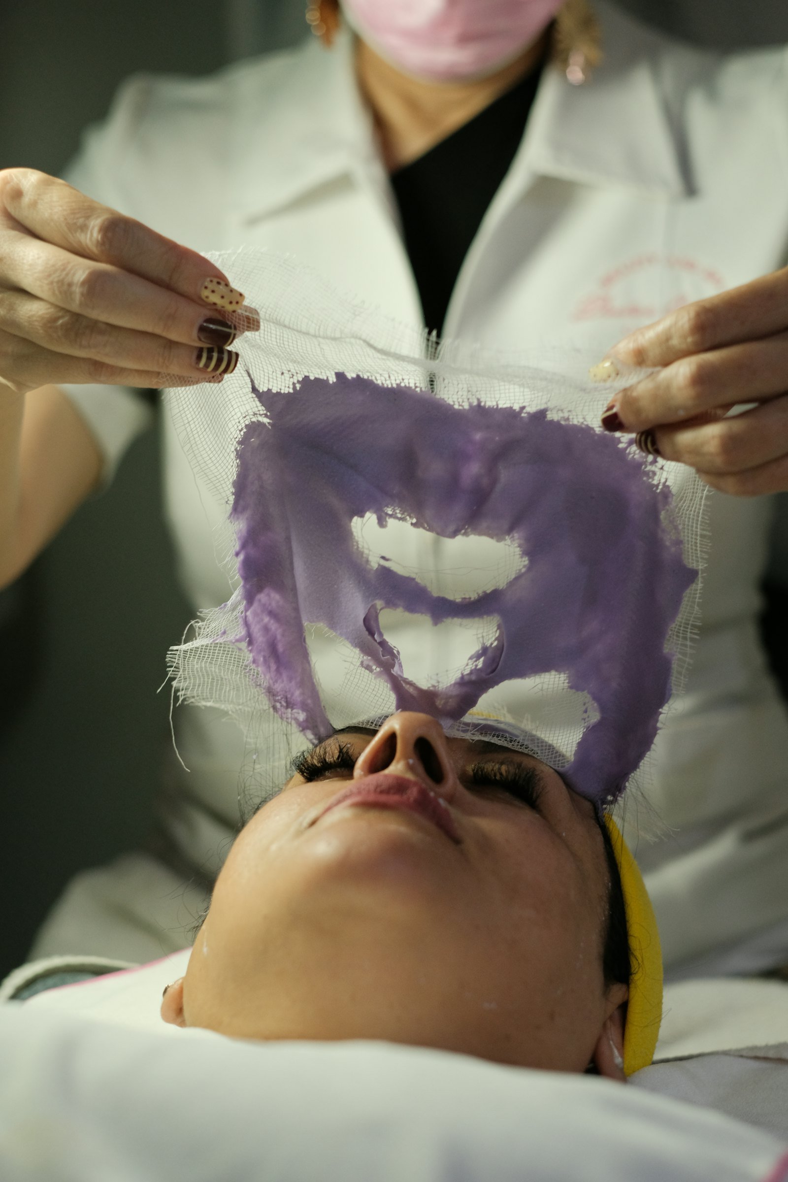Profesional de una clínica estética realizando un tratamiento facial