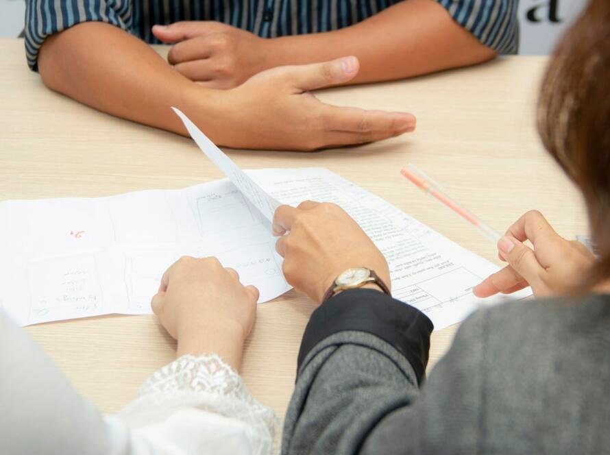 Dos personas revisando los números de un negocio sobre la mesa de reuniones